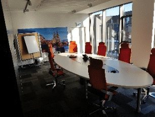 Konferenzraum mit ovalem Tisch und Flipchart